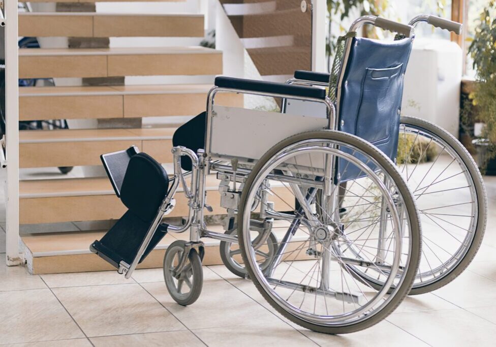 A Wheelchair on the Floor Near Stairs inside Home